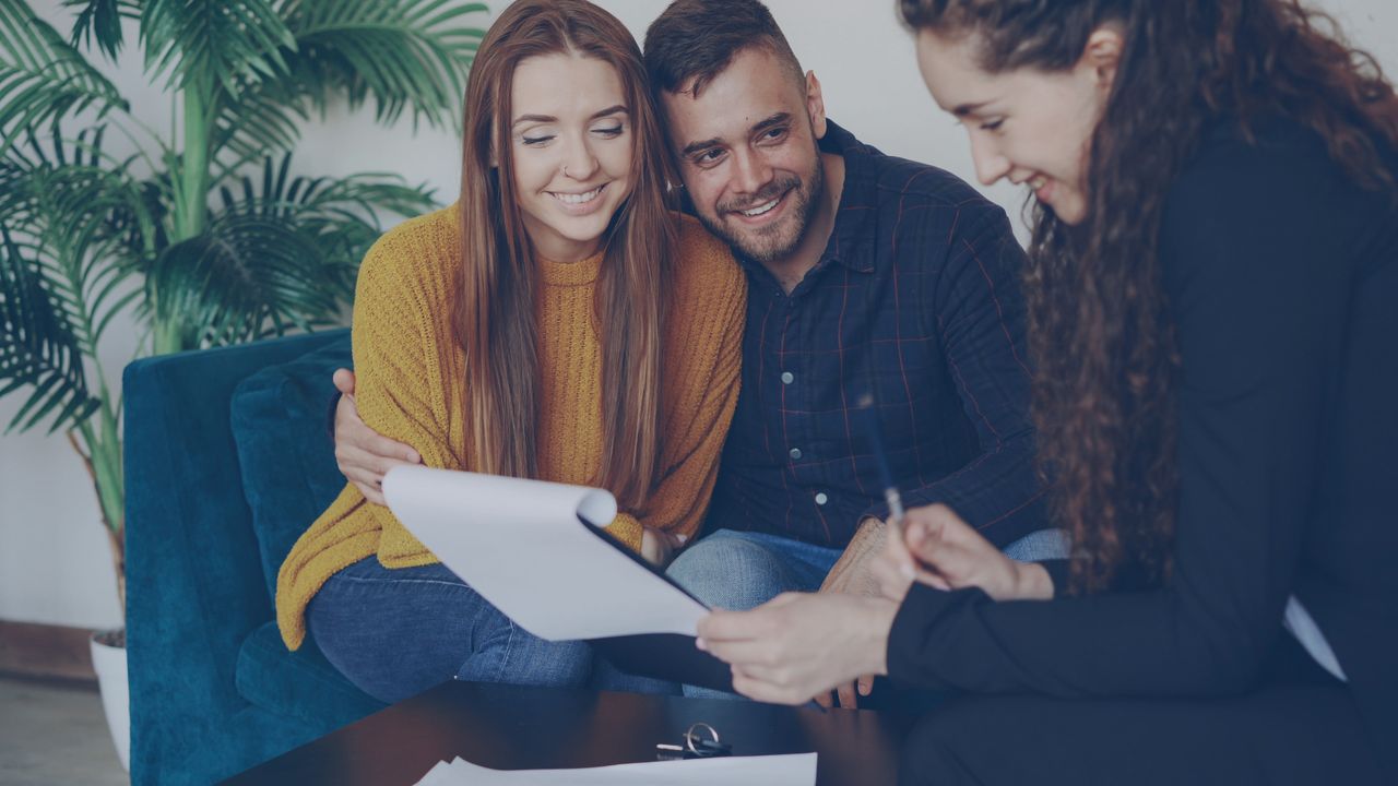 Crafting Captivating Headlines: Your awesome post title goes here Happy couple discussing finance with advisor in cozy office setting.
