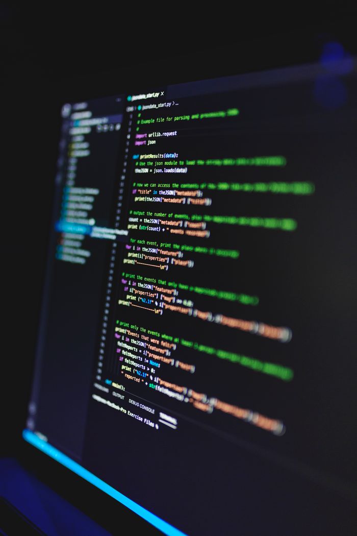 Services Vertical shot of colorful programming code on a screen in a dark room, highlighting technology work.